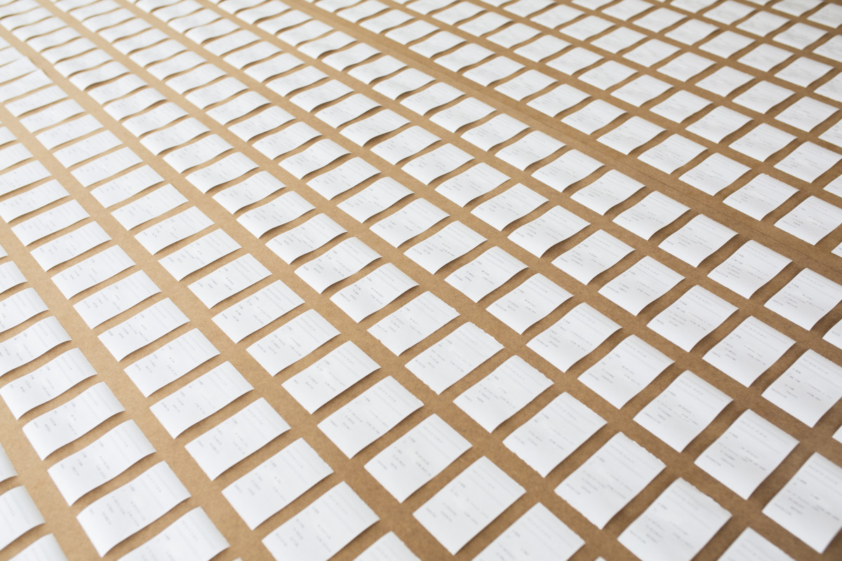 Unterschiedliche Textfragmente auf mehreren Druckobjekten mit der Asthetik eines Kassenzettels auf einen Tisch liegend.