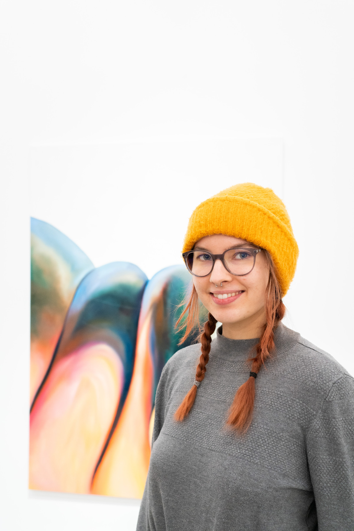 A portrait of Lisa Sophie Langhans in front of her painting 